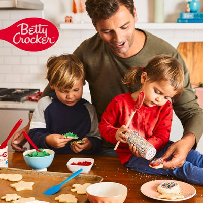Man and two children decorating cookies in a kitchen with Betty Crocker logo.